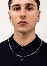 Cadena plateada de acero quirúrgico con eslabones tipo fígaro.