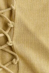 Top strapless cropped dorado, en tejido de punto acanalado con hilos brillantes, corte ajustado, con cordones cruzados en el frente y tiras halter finas para atar al cuello.