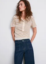 Pantalón wide leg de denim azul oscuro, de tiro alto con trabillas y cierre frontal de cremallera y botón. Presenta bolsillos de parche delanteros.