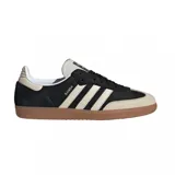 Championes Adidas modelo Samba OG, con diseño clásico de perfil bajo. Presentan una base de gamuza negra con las icónicas tres tiras laterales y puntera en tono crema, finalizando con una suela de goma color caramelo.