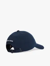 Gorra de béisbol azul marino Tommy Jeans, confeccionada en sarga de puro algodón con efecto lavado y desgaste. Presenta un parche ondulado con el logo de la marca en el frente y botón en la parte superior.
