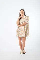 Vestido corto verde con estampado floral, cuello alto, mangas cortas abullonadas y corte holgado.