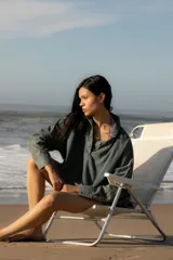 Vestido camisero corto de denim azul, con cuello camisero, cierre frontal con botones y mangas largas con puños abotonados.