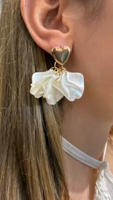 Aros colgantes con diseño de corazón dorado en la parte superior y pétalos de tela satinada blanca en la parte inferior.