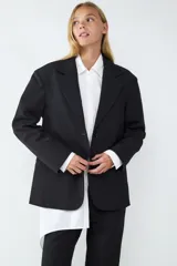 Blazer de corte oversize con cuello de solapa, manga larga y cierre frontal con botón. Cuenta con bolsillos delanteros con solapa.