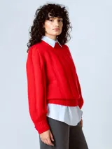 Sweater rojo de punto con cuello redondo y mangas largas abullonadas, con puños y dobladillo acanalados.