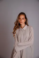 Camisa rosada con detalles de broderie en la parte delantera y mangas anchas.