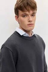 Sweater gris oscuro de punto con cuello redondo, manga larga y puños y dobladillo acanalados.