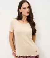 Pijama de dos piezas compuesto por una remera de manga corta en color beige con cuello redondo y un pantalón largo de corte recto con estampado de cuadros estilo argyle en tonos bordó y beige, con cintura elástica.