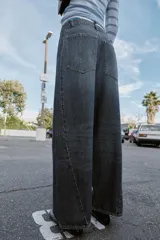 Jeans de tiro alto con corte balloon y pernera holgada. Presenta diseño de cinco bolsillos, cierre frontal con cremallera y botón, y detalle de costuras marcadas en el delantero y la espalda.