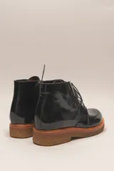 Bota acordonada de cuero vacuno con acabado charol color suela, con suela de goma tipo crepe y costuras reforzadas.