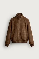 Cazadora bomber de corte regular fit en tejido efecto ante de color marrón, con cuello subido, cierre frontal de cremallera y bolsillos de vivo en la cadera. Presenta acabados elásticos en puños y cintura.
