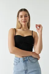 Top negro con breteles finos, escote recto y detalle de frunces en el centro.