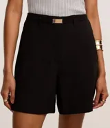 Short de sastrería color negro, de corte recto y cintura alta. Presenta trabillas para cinturón, un cinturón elástico con hebilla metálica y bolsillos decorativos en la parte posterior.