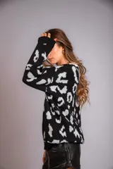Buzo negro con estampado animal print en blanco, cuello redondo y mangas largas.