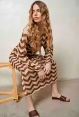 Vestido largo de lurex con diseño de patrón en zigzag en tonos tostado y marrón, escote en V con cordones para atar y mangas largas.