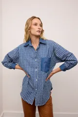 Camisa oversized de jean azul con estampado de rombos blancos. Tiene cuello, puños y un bolsillo en el pecho de jean liso.