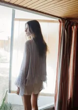 Blusa de poliéster con estampado de rayas, cuello con pañuelo integrado y detalle de abertura en V, de corte recto y mangas largas abullonadas con volantes.