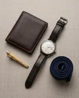Clip de corbata metálico en tono dorado con diseño minimalista de líneas grabadas.