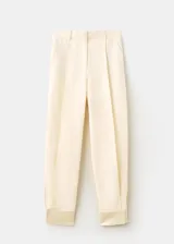 Pantalón balloon de tiro medio en color beige, con detalle de pinzas y bolsillos laterales.