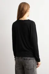 Remera de manga larga color negro, con elegante escote drapeado y diseño holgado.