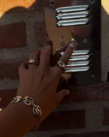 Pulsera de diseño artesanal elaborada eslabón por eslabón a mano, con eslabones circulares texturados de metal dorado y cadena regulable.