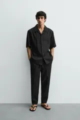 Pantalón relaxed fit de lino color negro, con cintura elástica ajustable con cordón y bolsillos frontales.