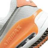 Championes Nike Air Max Systm de diseño deportivo, color blanco con detalles en gris claro, negro y verde neón. Presentan el logo de la marca en negro en el lateral y una unidad de aire visible en el talón con marco verde neón.