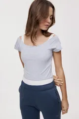 Remera blanca de corte ajustado y largo cropped, con escote redondo amplio y mangas cortas.