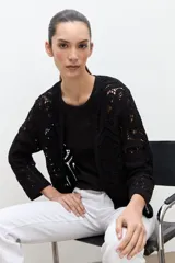 Chaqueta tejida a crochet en color negro, con diseño abierto sin cierre, mangas largas y terminaciones acanaladas.