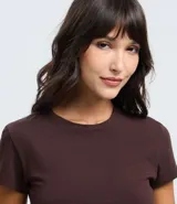 Blusa femenina de corte cropped, color verde oliva, con cuello redondo y mangas cortas. Confeccionada en algodón con elastano, ofrece un ajuste cómodo y versátil.