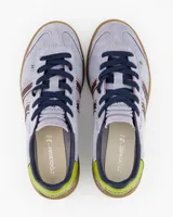 Championes Coolway modelo Kiro Lavender Rush, confeccionados en gamuza de color lila con detalles en marrón, rosa, verde lima y suela de goma marrón translúcida. Presentan diseño retro con doble franja lateral ondulada y cordones oscuros.