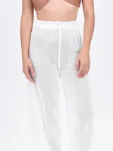 Pantalón ancho de tiro alto, color blanco, con textura tejida y elástico en la cintura.