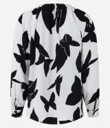 Blusa de crepé color blanco con estampado abstracto en negro, cuello redondo con cordón ajustable, mangas largas y barra trasera alargada.
