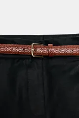 Bermuda negra de tiro alto con pinzas delanteras, bolsillos laterales y falsos bolsillos de vivo en la espalda. Incluye un cinturón delgado de cuero marrón con hebilla dorada.