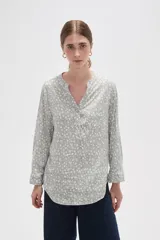 Blusa de viscosa con estampado floral pequeño, cuello mao con escote en V y cierre frontal parcial de botones. Presenta mangas largas con puños y un bolsillo frontal en el pecho.