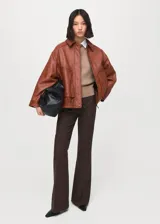 Chaqueta de cuero de ovino en color marrón, de diseño oversize con cuello clásico, cierre frontal con botones a presión y bolsillos frontales con solapa.