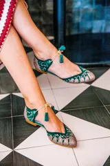 Bailarinas con base de rejilla animal print verde y glitter fino multicolor. Cordón beige con borla a juego.