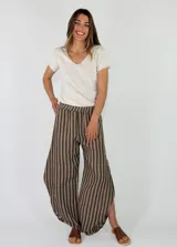 Pantalón de lino amplio y fluido, con diseño de rayas verticales en tonos beige y marrón, cintura elástica y corte relajado.