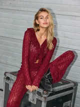 Blusa de manga larga con escote en V, volados frontales y tejido calado semi-transparente, confeccionada en punto liviano de fit ajustado.