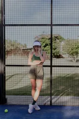 Top deportivo verde con breteles finos y contorno blanco.