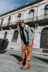 Pantalón de cuero de tiro alto y silueta recta, con cierre frontal, botón y bolsillos funcionales.