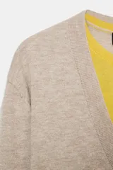Jersey de punto con lana, de diseño combinado con cuello en V profundo en color beige y detalle interior en color amarillo. Presenta mangas largas con puños ajustados.