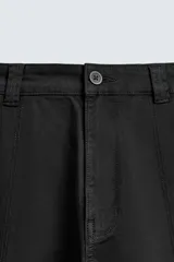 Pantalón cargo de corte relajado confeccionado en tejido de algodón con elasticidad. Presenta bolsillos laterales tipo cargo con solapa en las perneras, bolsillos frontales y bolsillos traseros de doble vivo. Cierre frontal con cremallera y botón.