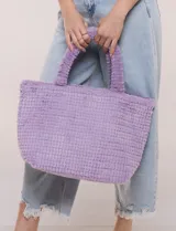Cartera tipo shopper verde de textura suave y flexible, con doble asa superior fija texturada y compartimento principal amplio con botón metálico.