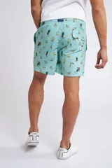 Short de baño con cintura elástica y cordón ajustable, confeccionado en tela ligera de secado rápido. Presenta un estampado botánico integral en tonos amarillos, blancos y azules, con dos bolsillos delanteros y uno posterior.