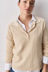 Sweater de punto color verde militar, con cuello polo y cierre frontal de botones, de manga larga con puños elastizados y diseño texturizado con relieve geométrico.