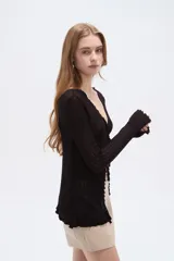 Saco abierto de viscosa color blanco, con cuello en V, lazo para anudar al frente y mangas largas con terminación ondulada.