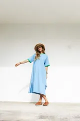 Vestido largo marrón con cuello redondo y mangas cortas con ribete amarillo. Estampado frontal con letras en color crema.