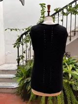 Chaleco tejido a mano en dos agujas con hilado 100% baby alpaca teñido artesanalmente, color magenta matizado. Diseño ligeramente oversize, de hombros anchos y cuello tipo bote, con puntos calados en frente y espalda y tajos a los lados en el bajo.